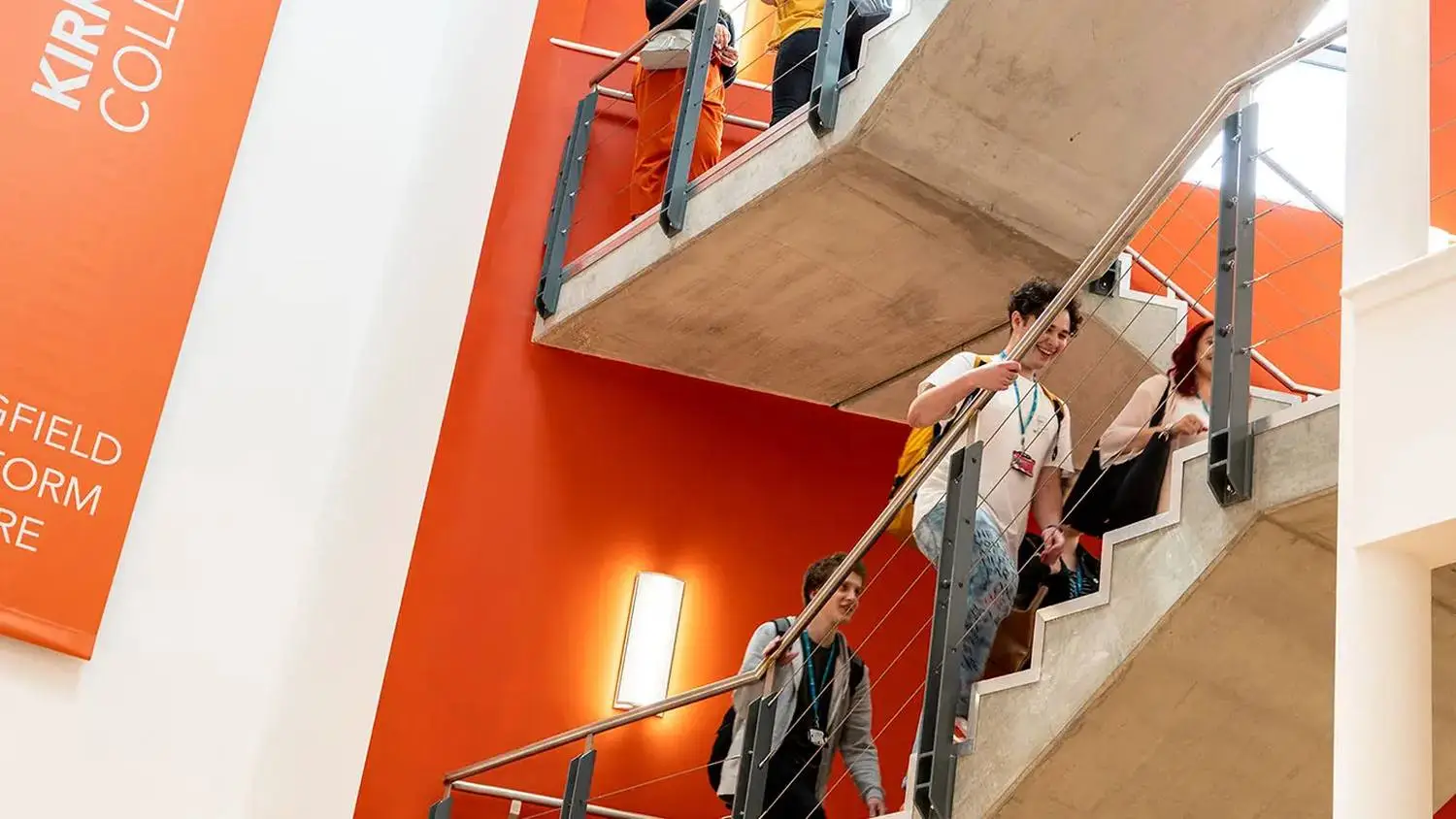 students on staircase with orange walls