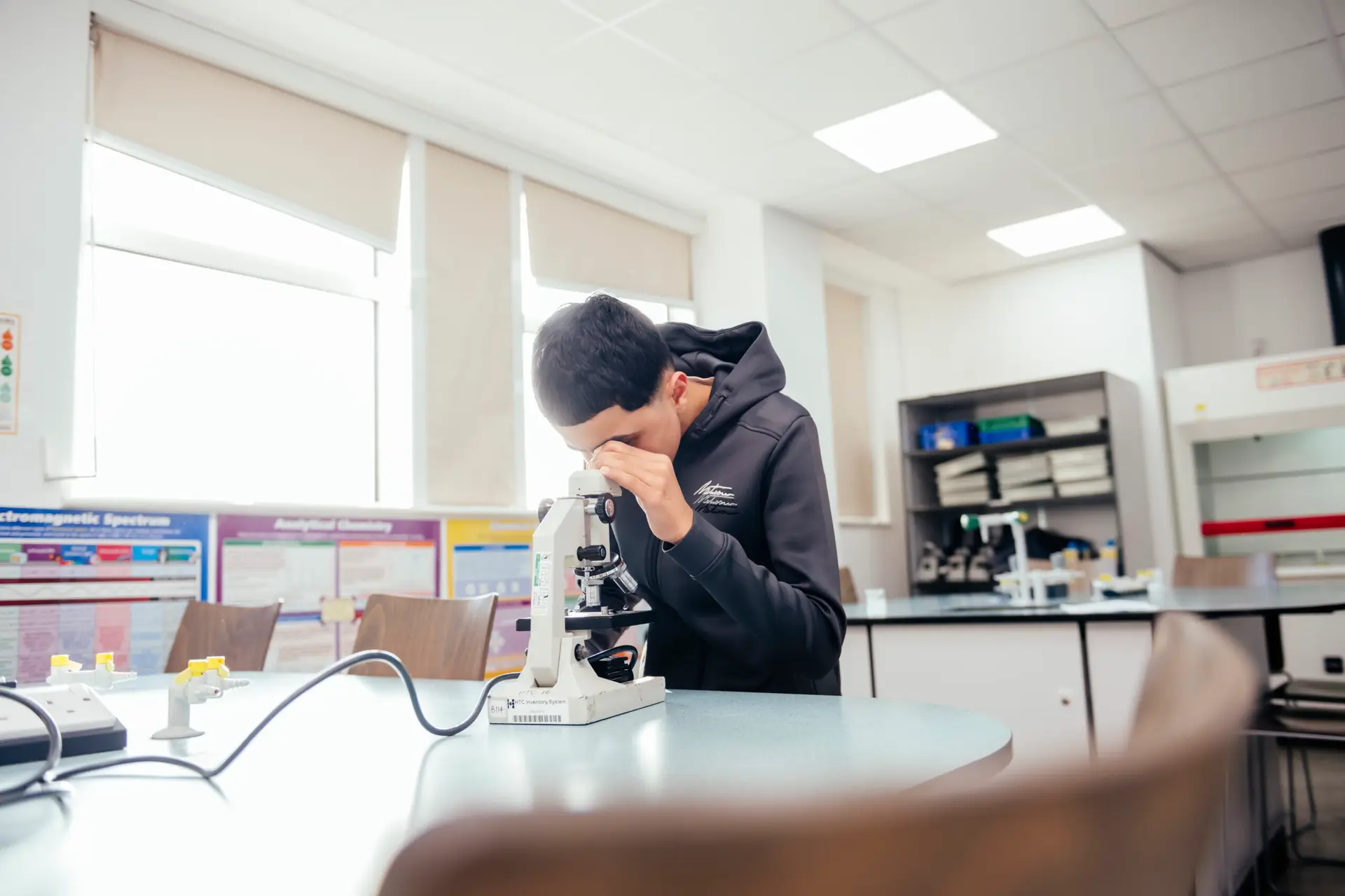 Student looking down a microscope