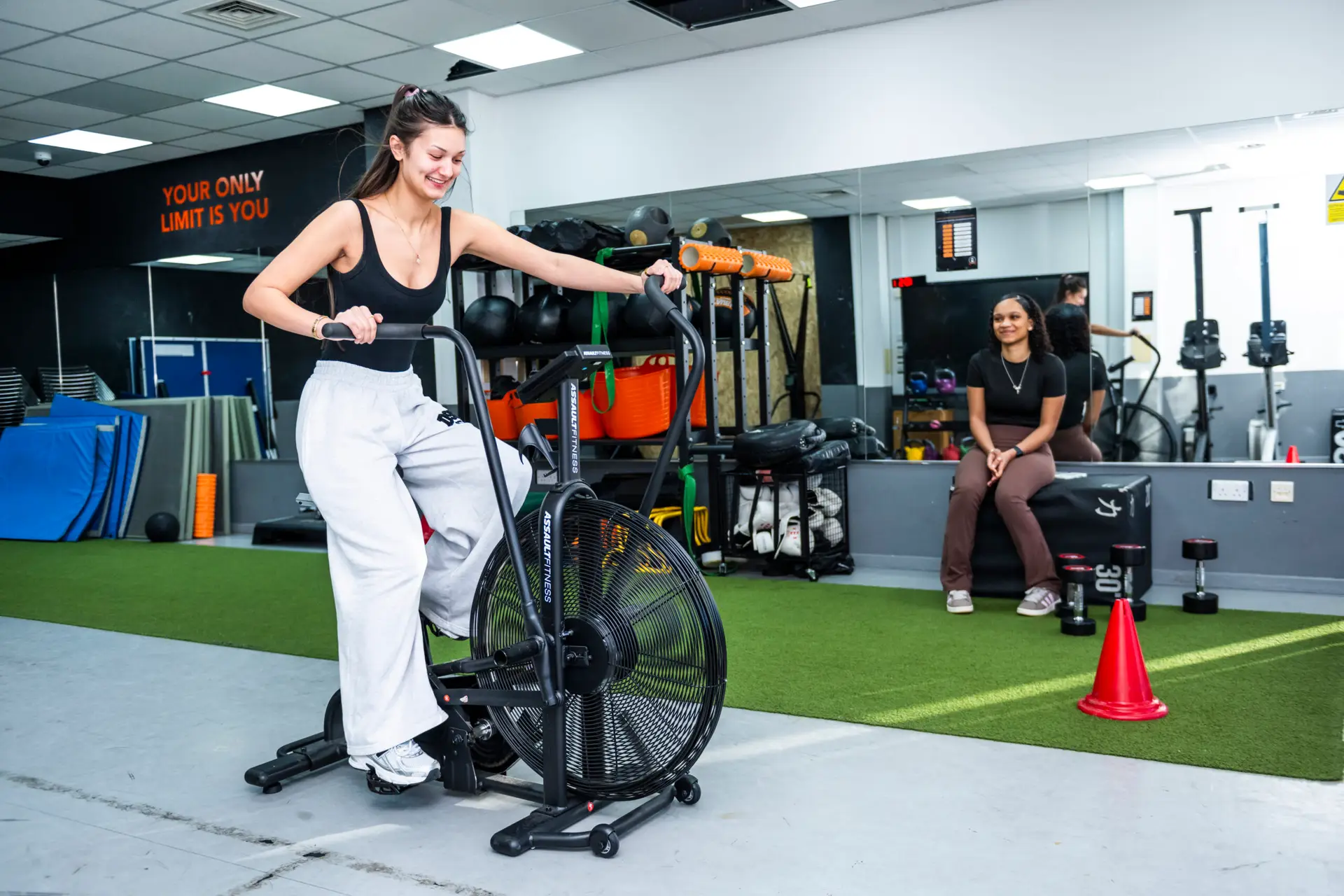 Student on exercise bike with another watching on