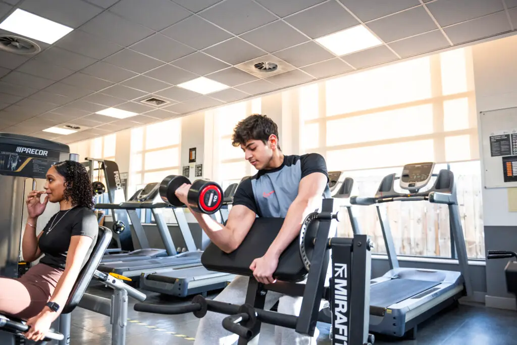 Students in gym lifting weights