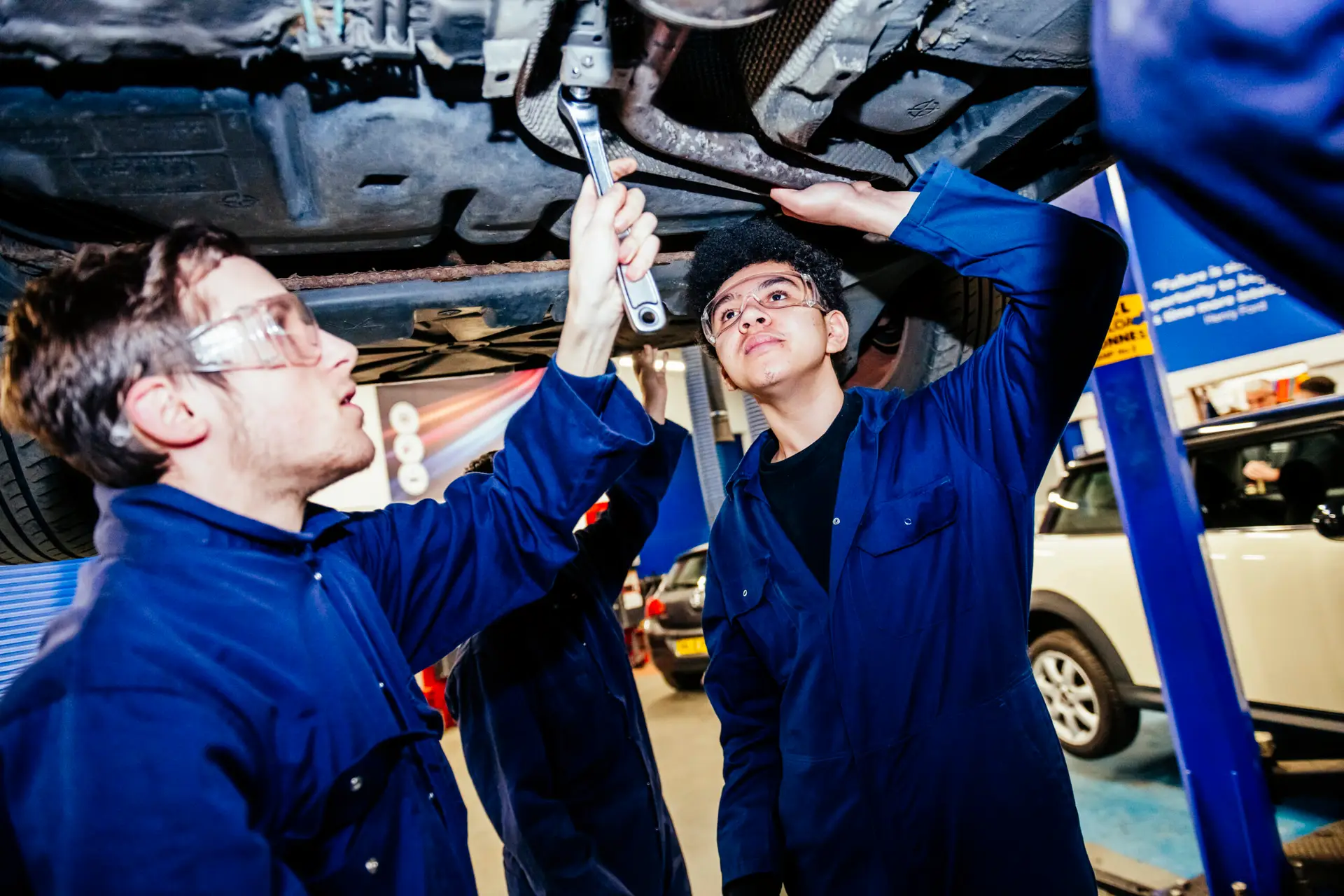 Students working under car