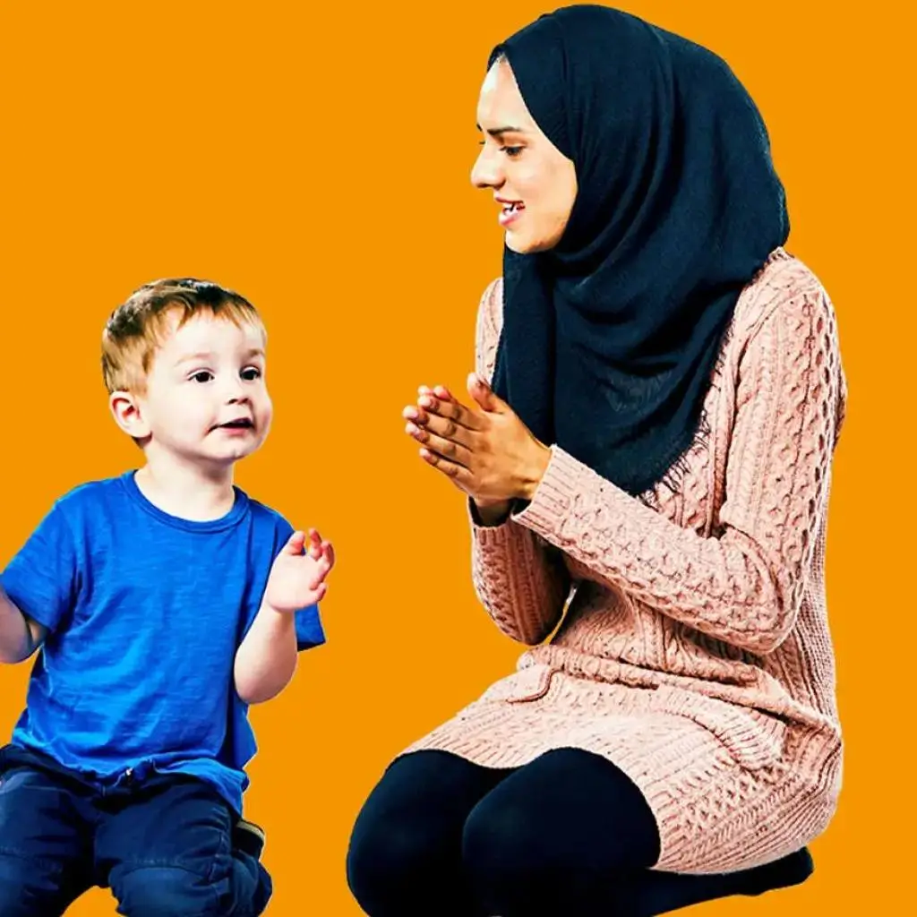 A woman in a pink sweater and a child in a blue shirt clapping hands against an orange background.