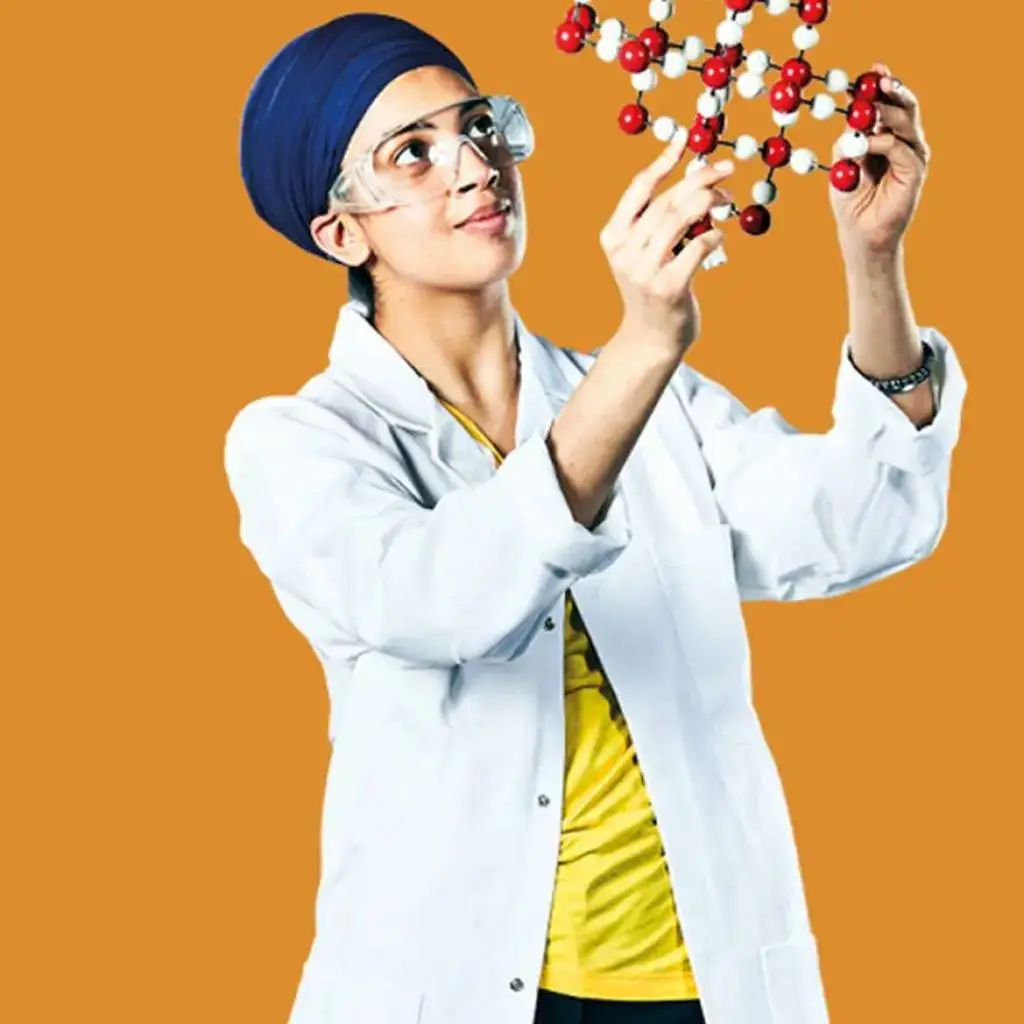 A person in a lab coat and goggles examines a molecular model against an orange background.