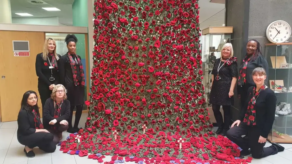 wall of roses, made by student wearing black suits