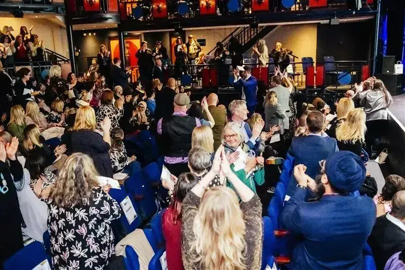 Picture of a theatre stalls full of people