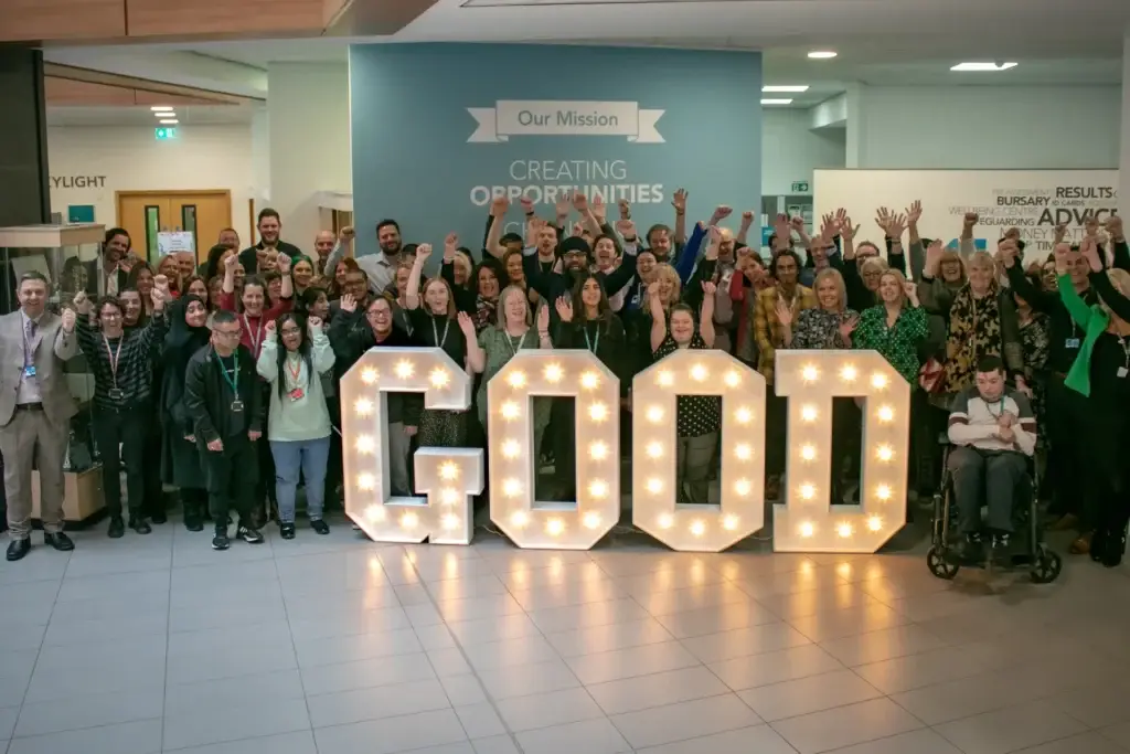 Students and staff stand behind letters spelling 'GOOD' to celebrate Ofsted result.