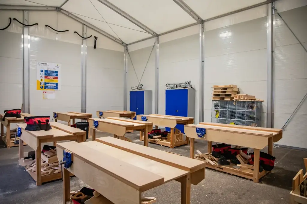 Woodwork benches in aa tent with white walls