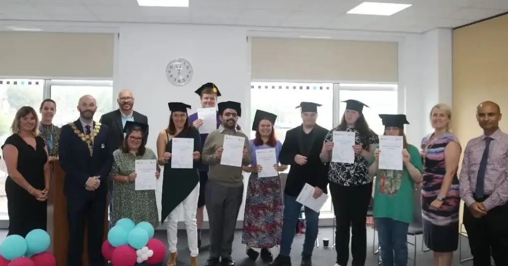 Graduates pose for a photo with the mayor at their graduation ceremony