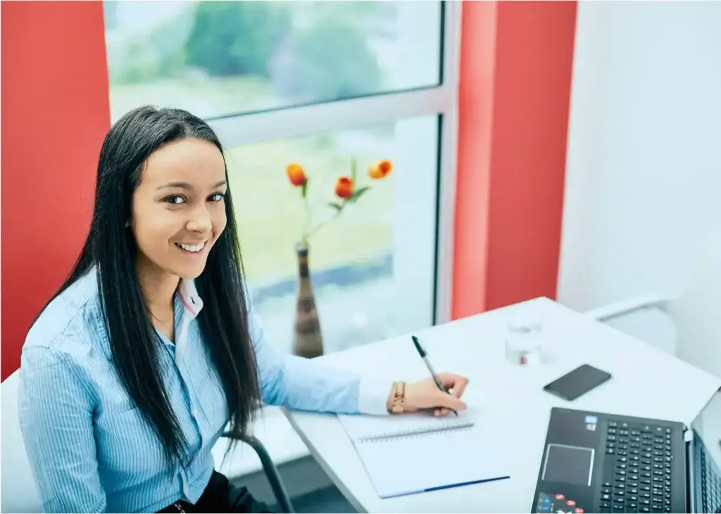 girl with smiling face doing work on laptop
