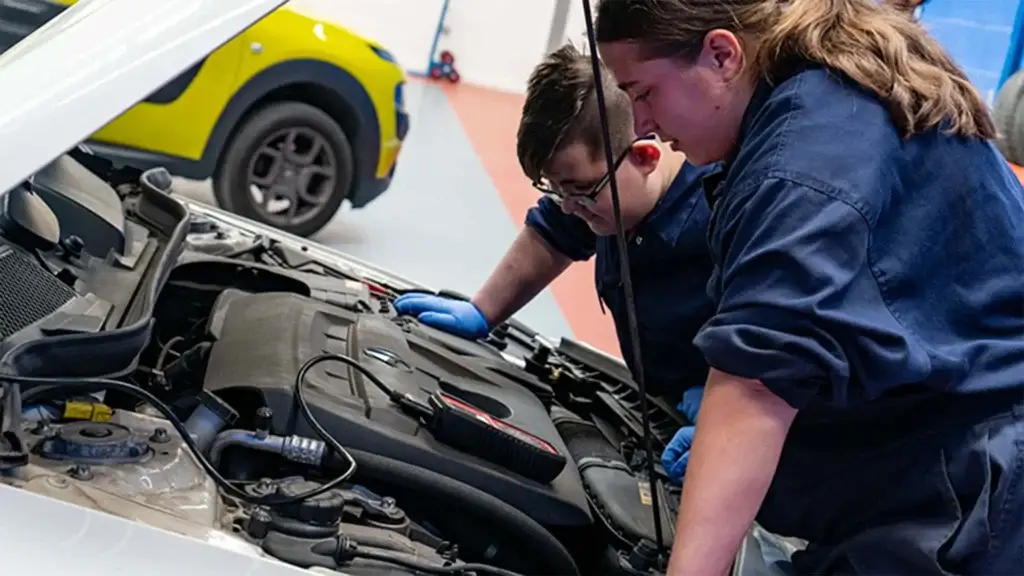 boy and girl working on car
