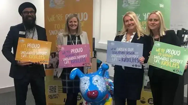 4 person smiling and showing card boards