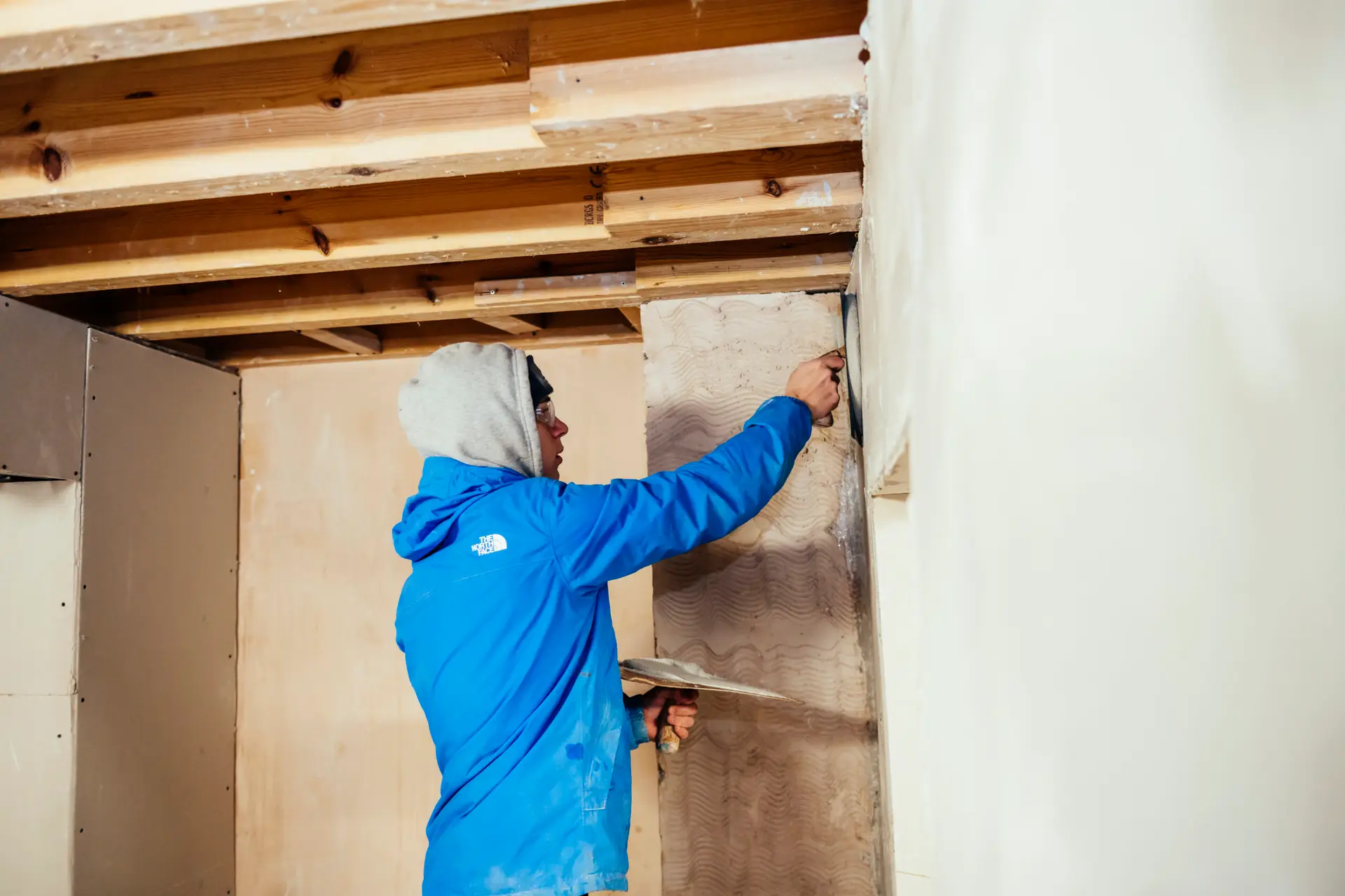 student plasters a wall
