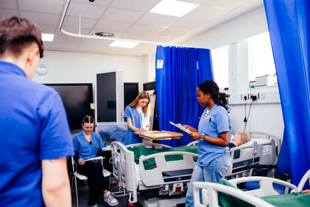 Students in blue scrubs in mock ward