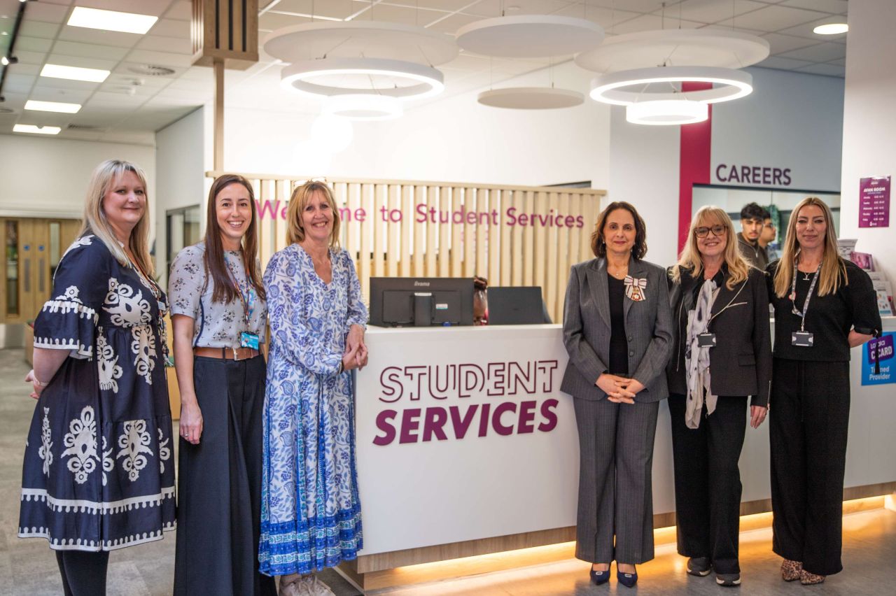 Kirklees College staff pose in front of Student Services sign