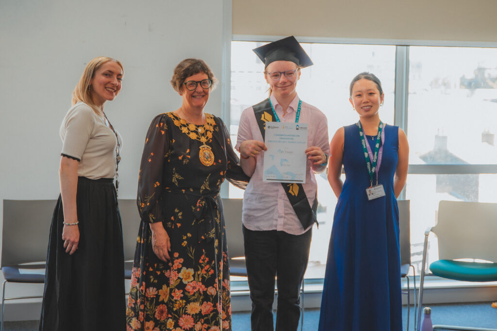 student with staff at graudation