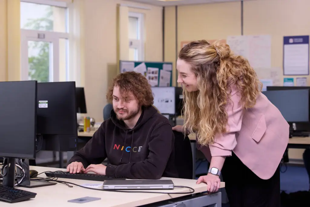 student with teacher in IT room