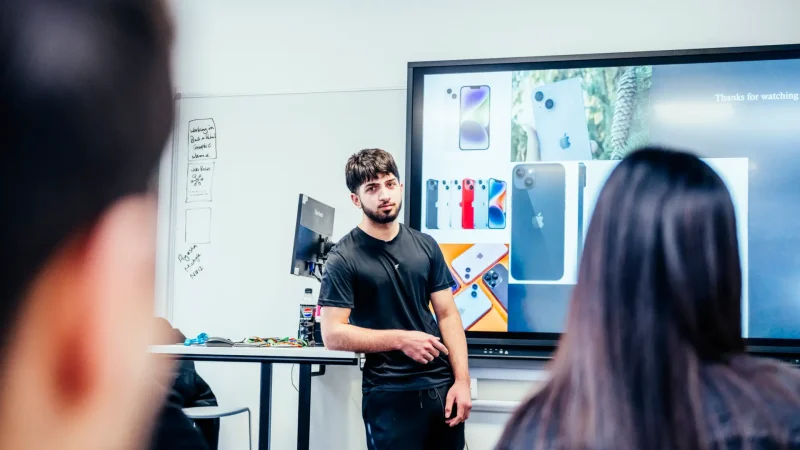 teacher showing the apple phone features on screen