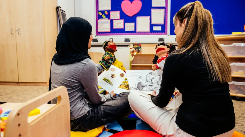 Childcare students with books and puppets