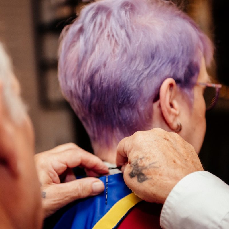 Two people pinning a Romanian flag to a person's shirt.