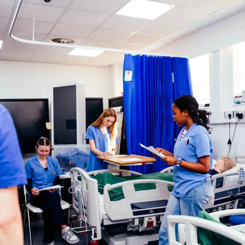 health student talks to staff in mock ward
